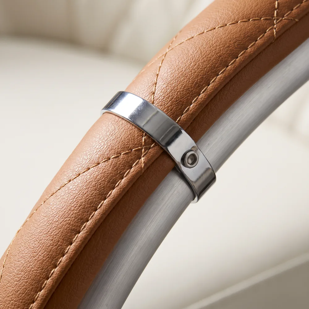 Close view of quilted tan PU leather stitching meeting a brushed aluminium frame tube.